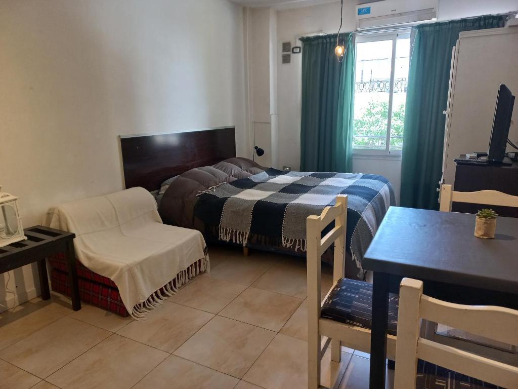 um quarto com uma cama, uma cadeira e uma mesa em Mitre 228 em Rosário