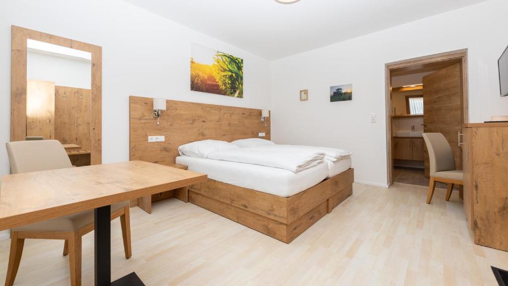 Schlafzimmer mit einem Bett, einem Tisch und Stühlen in der Unterkunft Schönfelderhof 