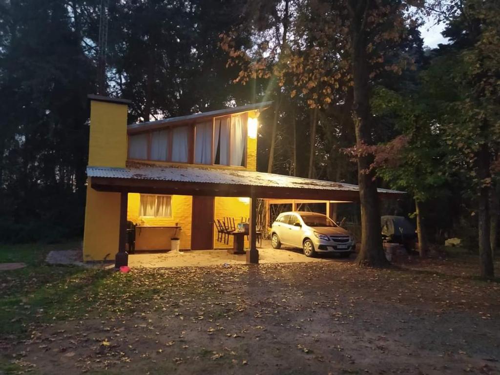 una casa con un coche aparcado delante de ella en Quinta Los Cardales en Los Cardales