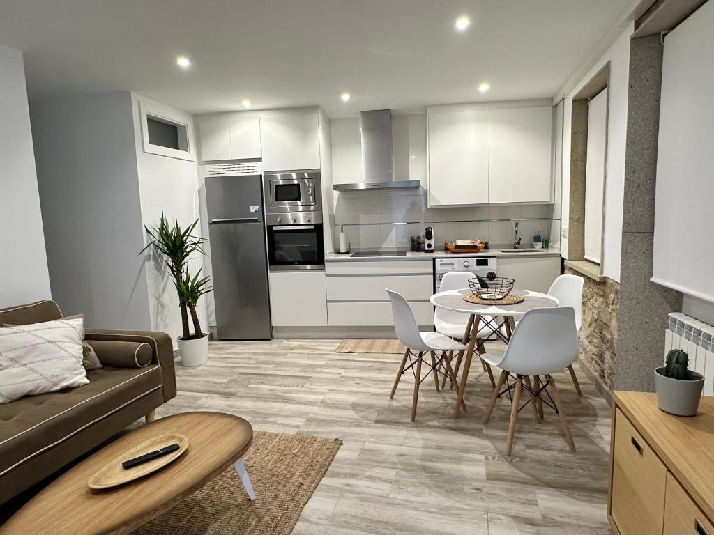 eine Küche und ein Wohnzimmer mit einem Sofa und einem Tisch in der Unterkunft Apartamento Lux Santiago in Santiago de Compostela