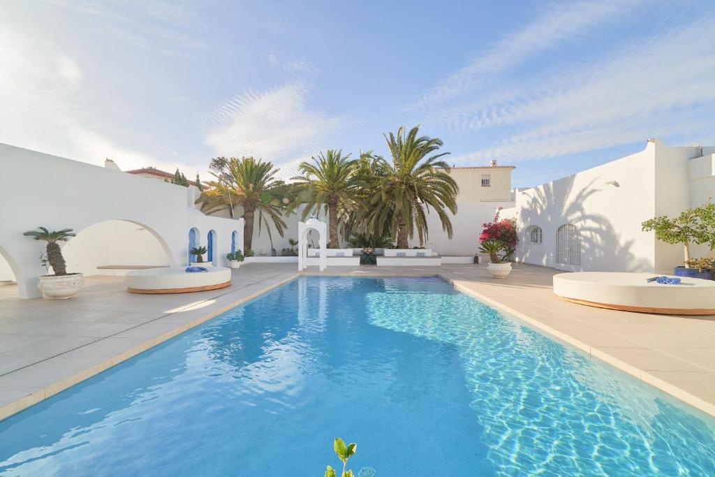 a swimming pool in front of a white house at Mauresque Experience Luxury in Torremolinos