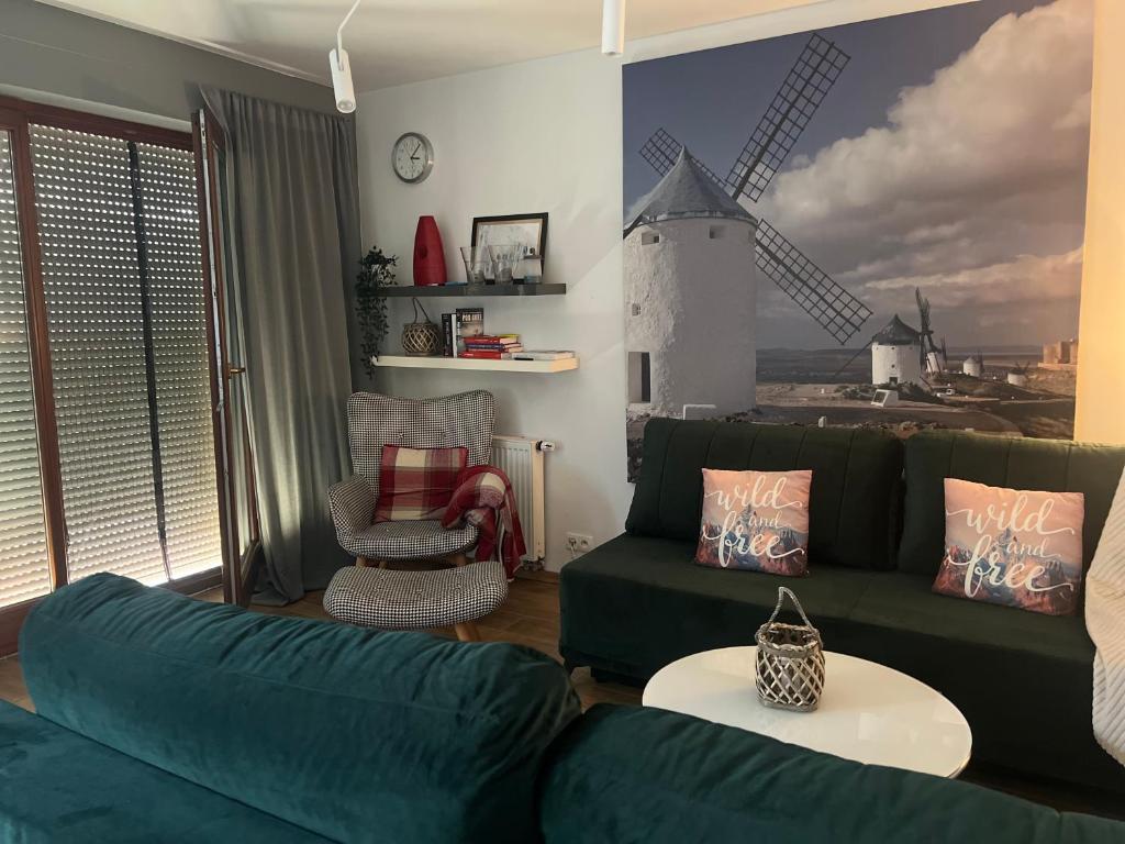 a living room with a green couch and a windmill at Bike - Apartament Ustroń Orzechowa 66 in Ustroń