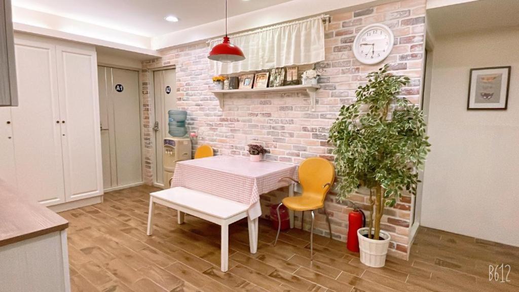 a kitchen with a table and chairs and a brick wall at 逢甲歡樂屋 in Taichung