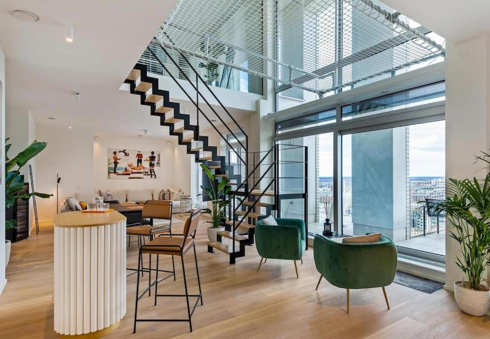 uma sala de estar com uma escada e cadeiras verdes em Sky loft - Luxurious Penthouse - Antwerp 180 m² em Antuérpia