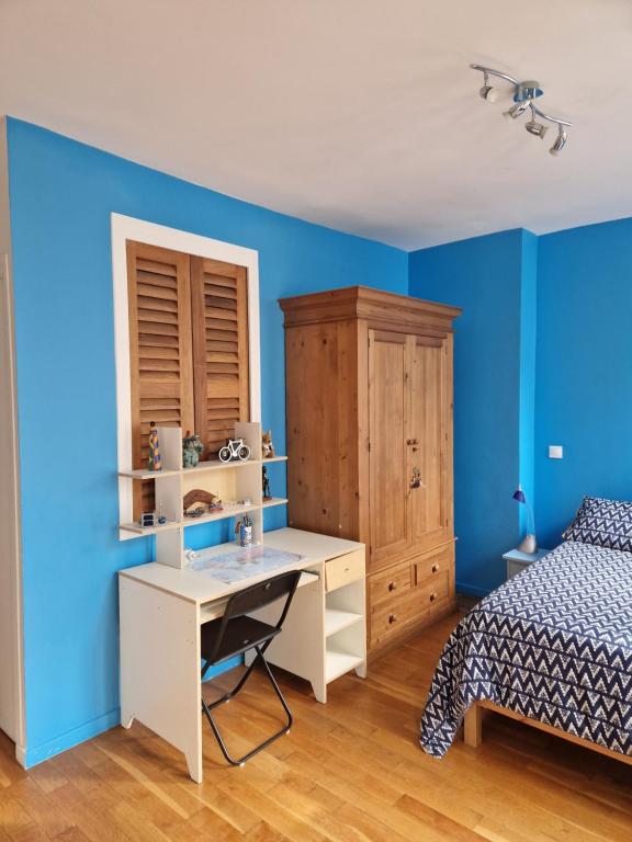a bedroom with blue walls and a bed and a desk at Loft en duplex 270 m2 &amp; Jardin patio terrasse sauna in Chaville