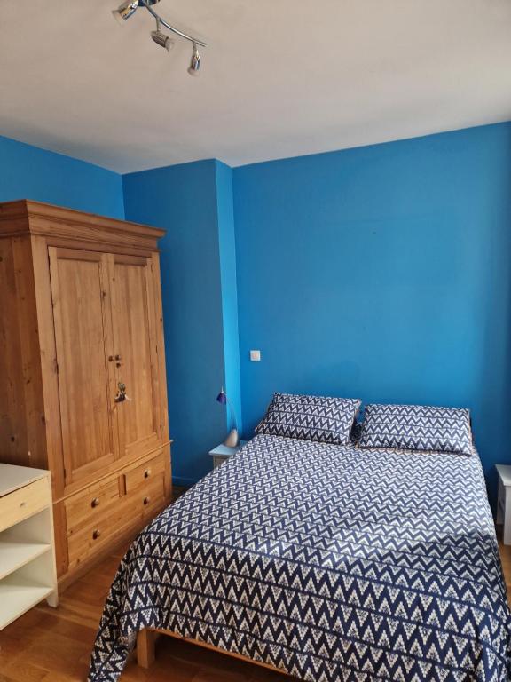 a blue bedroom with a bed and a wooden cabinet at Loft en duplex 270 m2 &amp; Jardin patio terrasse sauna in Chaville