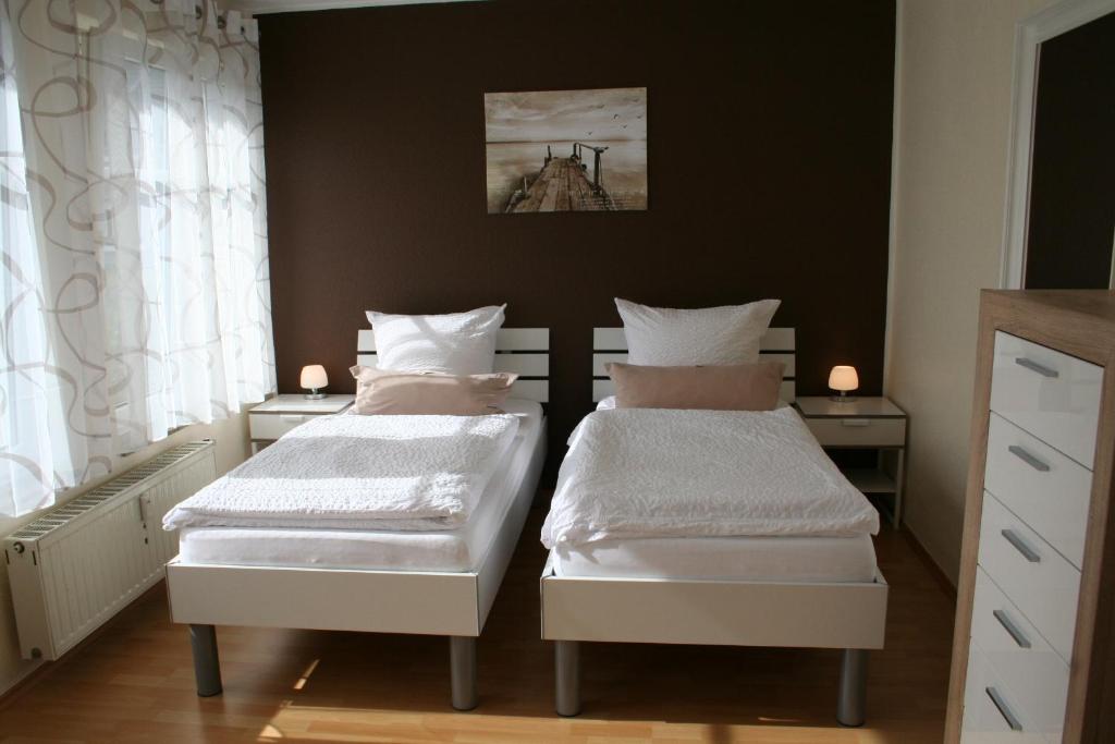 レスラートにあるApartment Messezimmer Flughafen Köln Bonnの黒い壁のベッドルームにベッド2台が備わります。