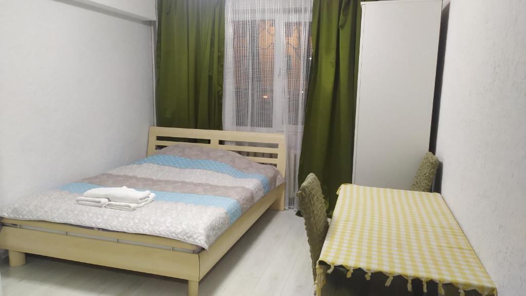 ein kleines Schlafzimmer mit einem Bett und zwei Stühlen in der Unterkunft уютная комфортная квартира студия in Chişinău