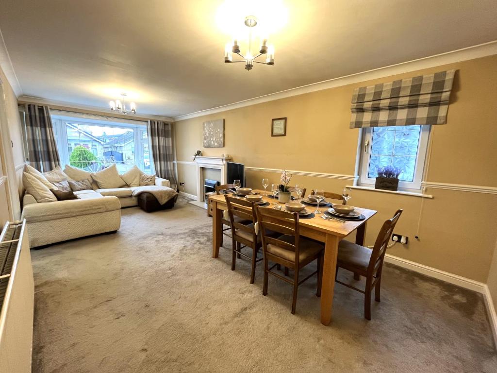 a living room with a table and chairs and a couch at Tranquil 3-bedroom bungalow 