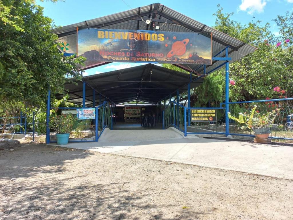 einen Pavillon mit einem Schild, das Disneys Dinosaurier darauf liest in der Unterkunft Posada Turística Noches De Saturno in Villavieja