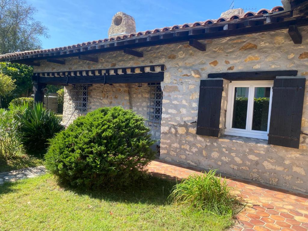 une maison en pierre avec une fenêtre sur le côté de celle-ci dans l'établissement Villa a 2mn de la plage, à Saint-Georges-de-Didonne