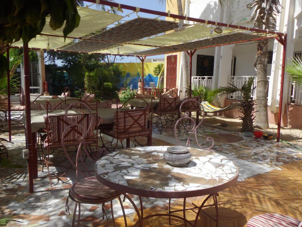 eine Terrasse mit einem Tisch, Stühlen und einem Sonnenschirm in der Unterkunft Auberge Triskell in Nouakchott