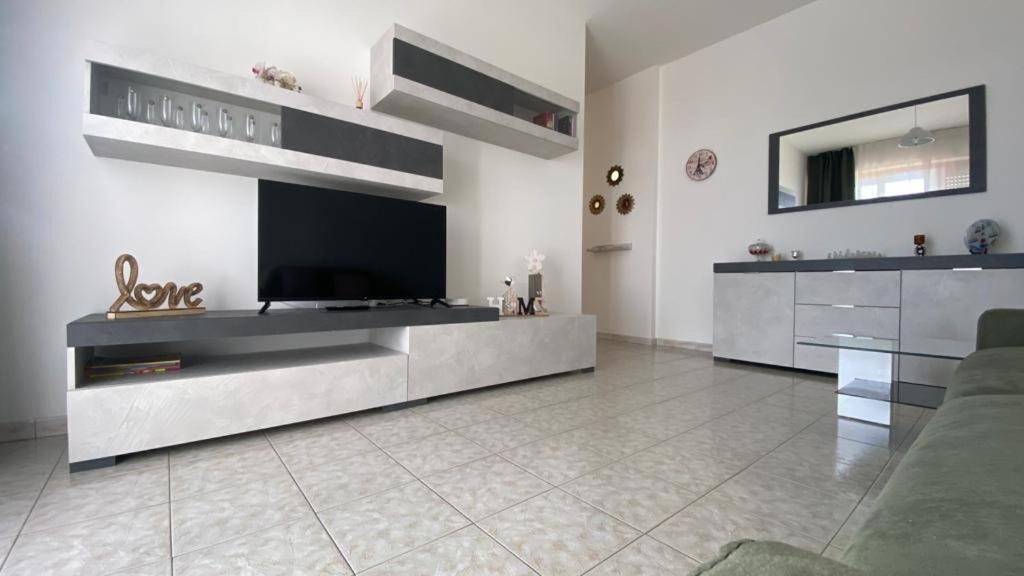 een grote woonkamer met een televisie en een bank bij Saronno 800 mt dalla stazione in Saronno