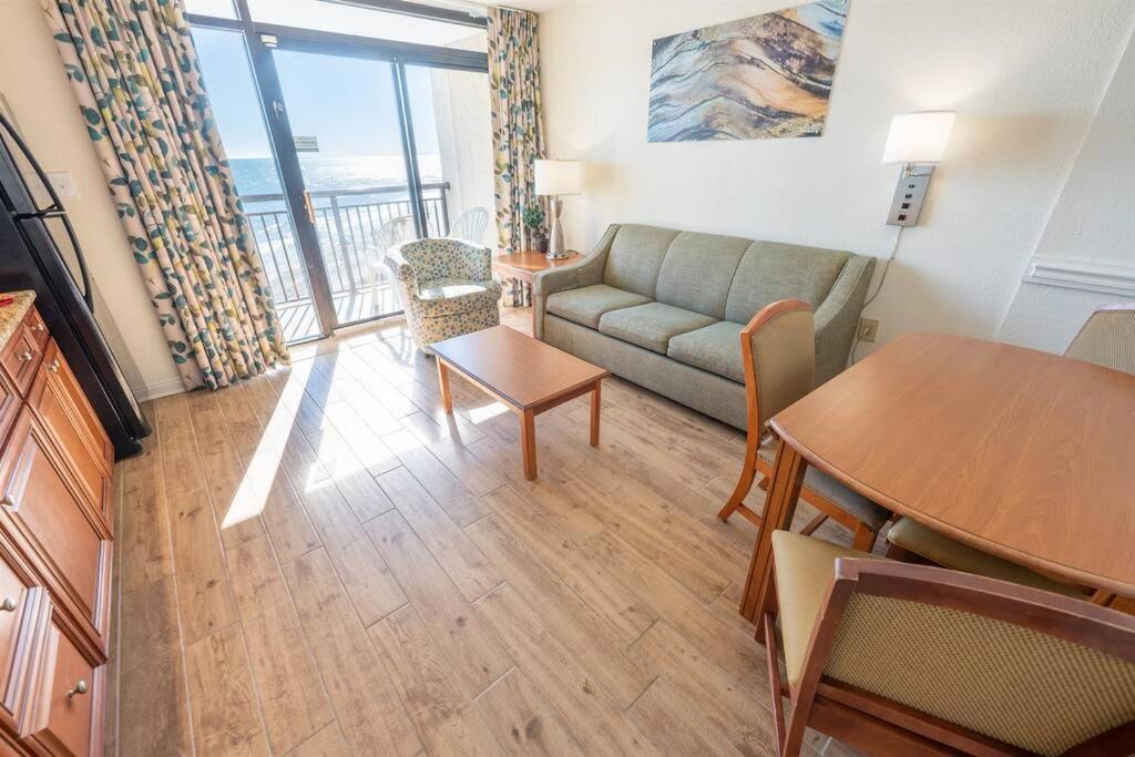 uma sala de estar com um sofá e uma mesa em New Remodeled Direct Oceanfront Views @ Beach Cove em Myrtle Beach