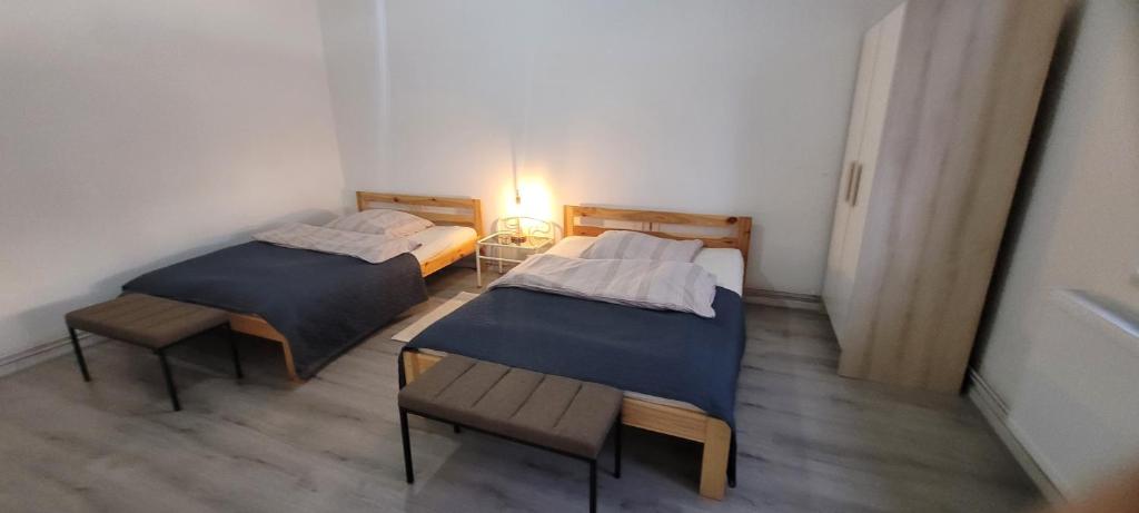 duas camas num quarto com uma mesa e um candeeiro em Ap 5 51qm bei Oschersleben und Helmstedt em Ausleben