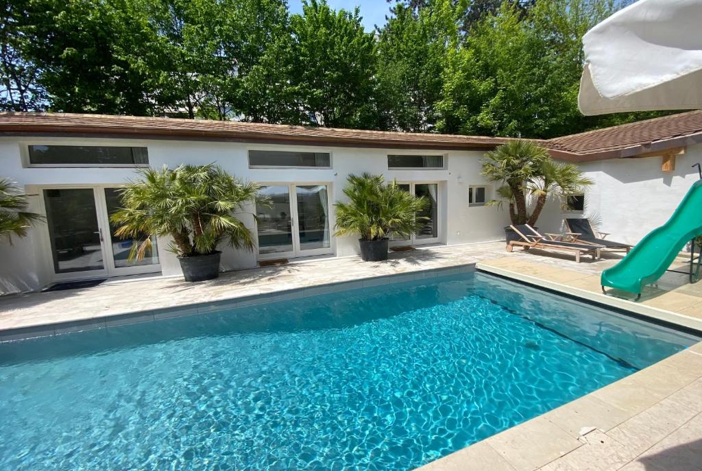 a swimming pool with a slide in front of a house at Residence Mont-Blanc Poolhouse in Geneva