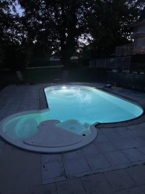 a small swimming pool in a backyard at night at Le Bois Perrin in Joinville