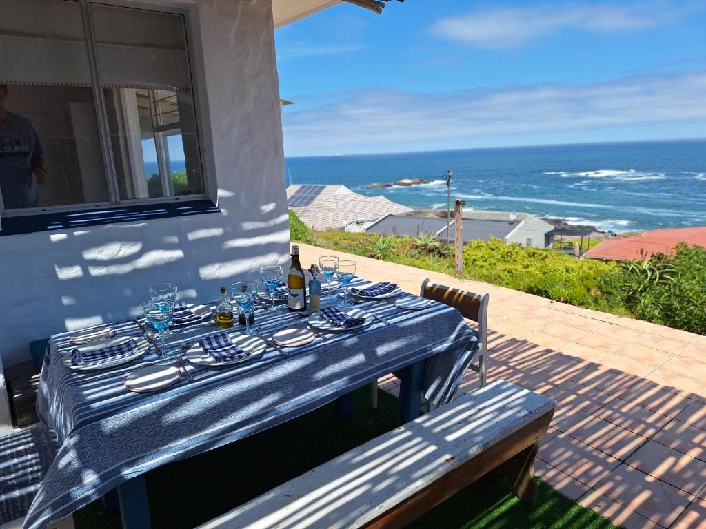 una mesa azul puesta en un patio con el océano en Sea View, en Yzerfontein