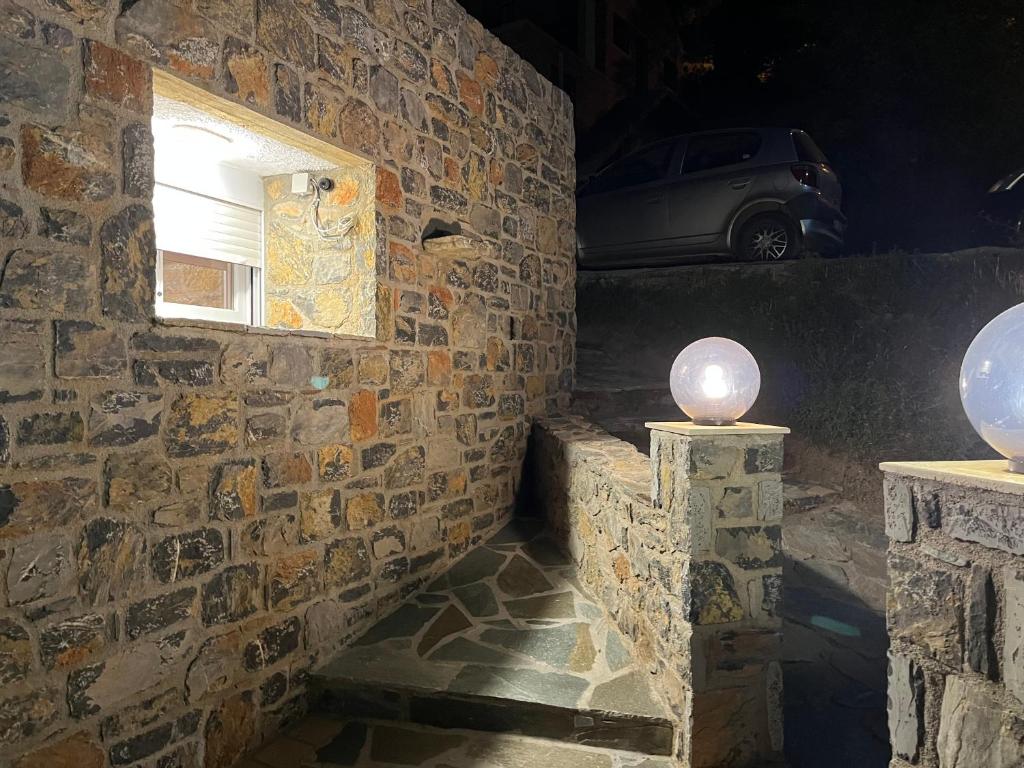 Habitación con pared de piedra, ventana y coche en The Small Mountain house en Séta