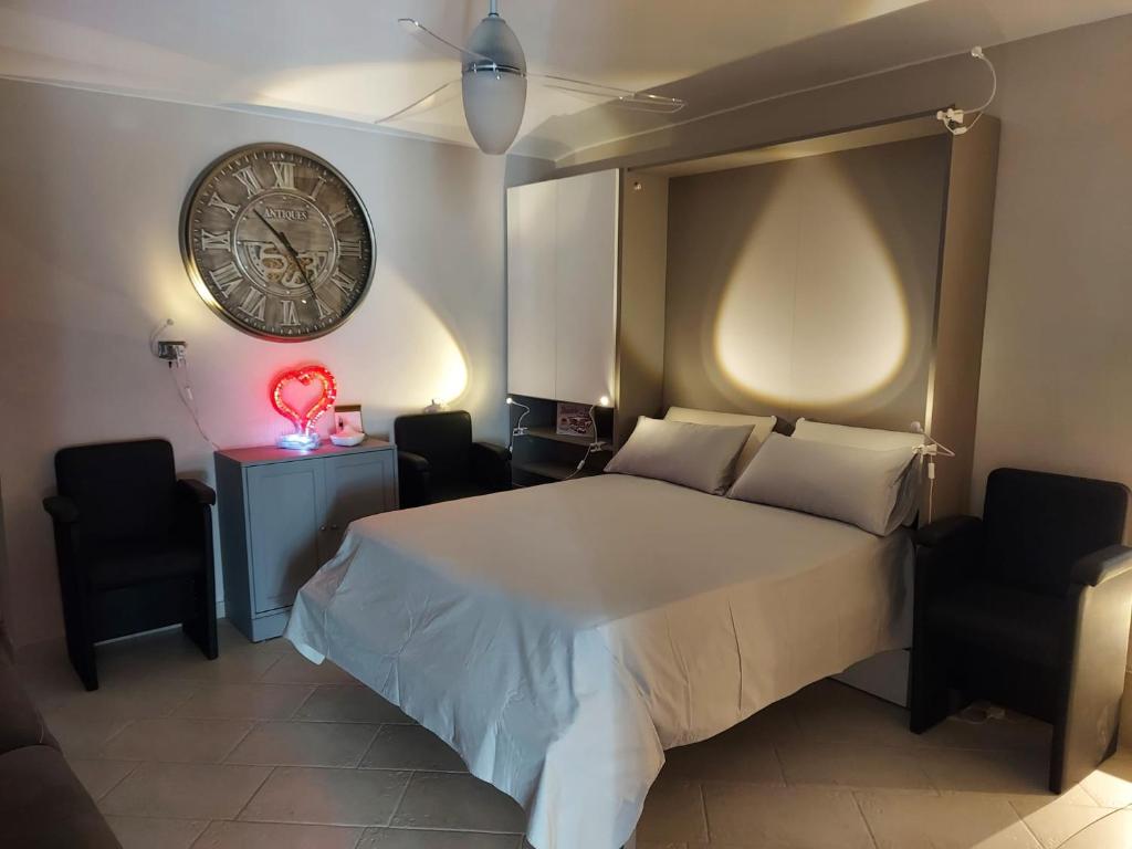 ein Schlafzimmer mit einem Bett und einer Uhr an der Wand in der Unterkunft Dimora Rosso 27 in Fiano