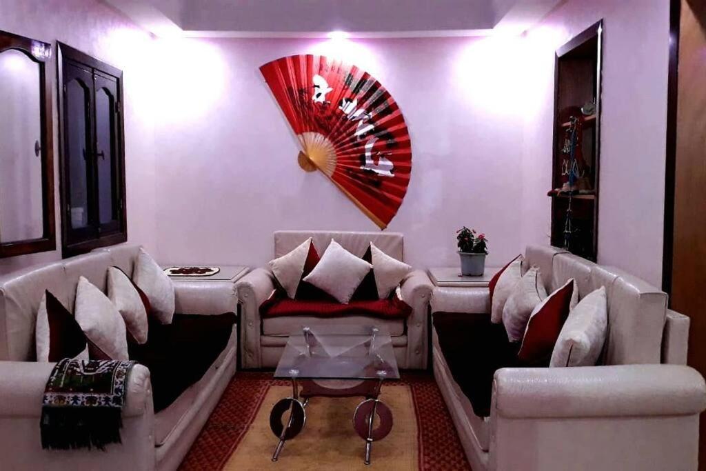 Sala de estar con 2 sofás y mesa en Joli Appartement Vue Montagne en Xauen
