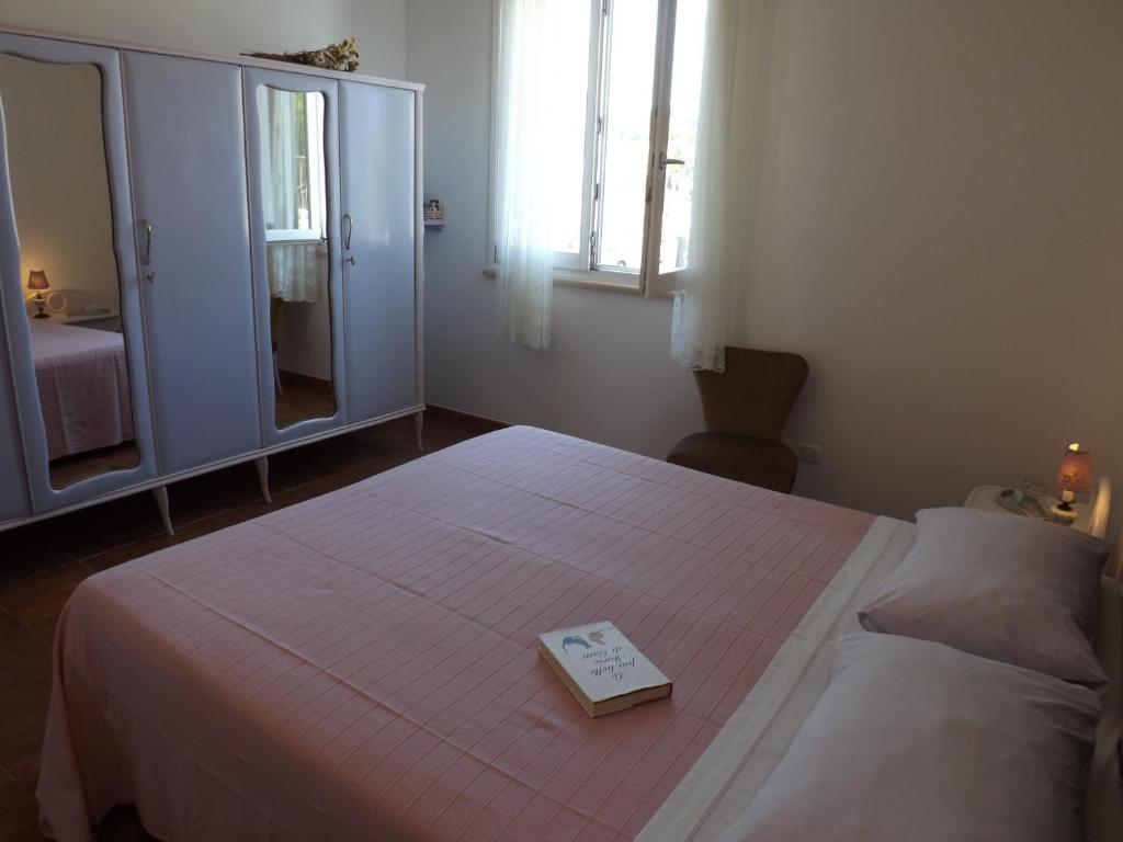 a bedroom with a bed with a book on it at B&B Il Gatto Pescatore in Stintino