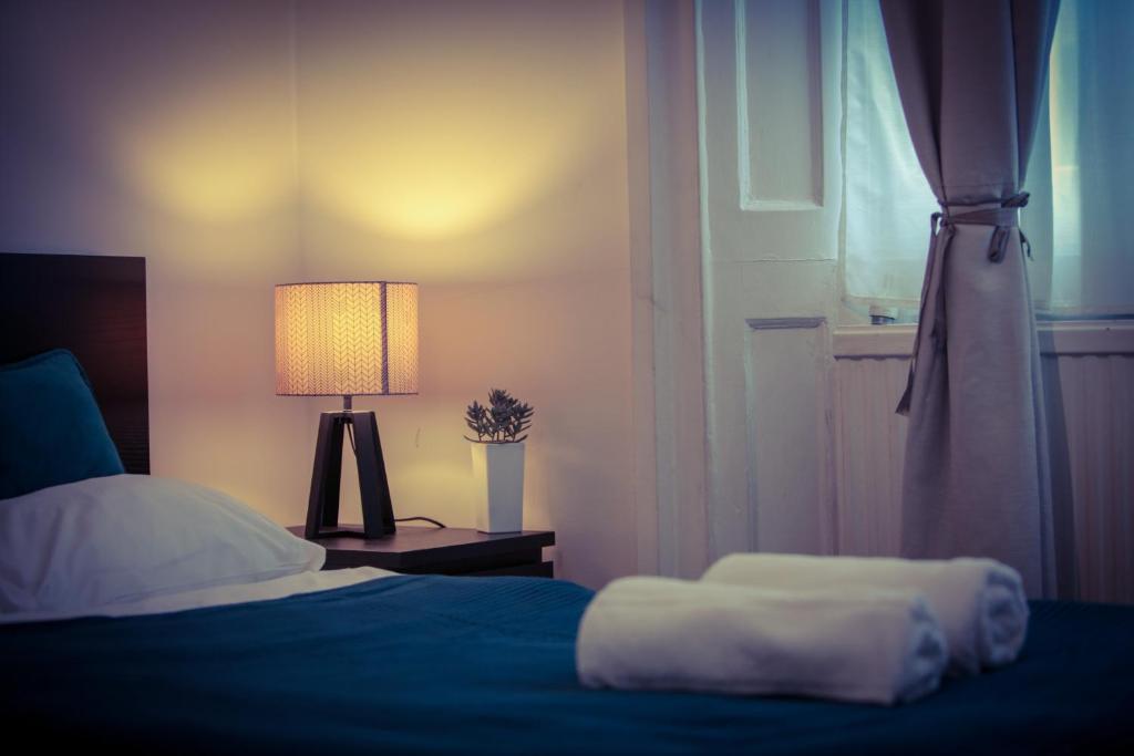 a bedroom with a bed and a lamp and a window at Warren Apartment in London