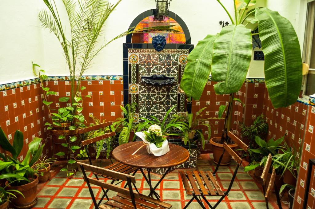 un patio con mesa, sillas y plantas en Pension Perez Montilla, en Sevilla