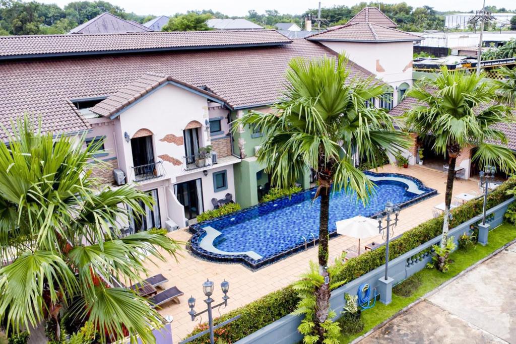 an aerial view of a house with a swimming pool and palm trees at Hotel Toscana Trat in Trat