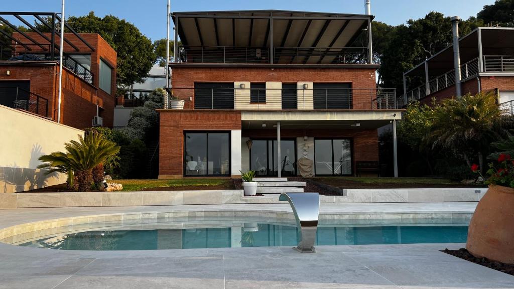 a house with a swimming pool in front of a house at Casa Elisabeth in Castelldefels