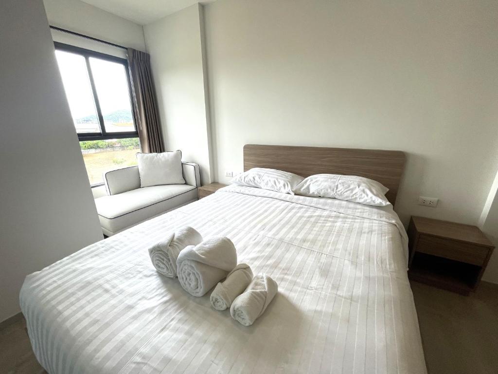 een slaapkamer met een wit bed met handdoeken erop bij Downtown In Huahin la casita in Hua Hin