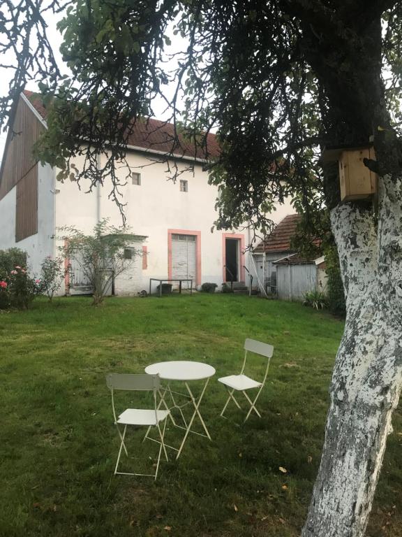 a table and two chairs in the yard of a house at Domaine La Bonne Dame I, au coeur des Vosges in Plainfaing