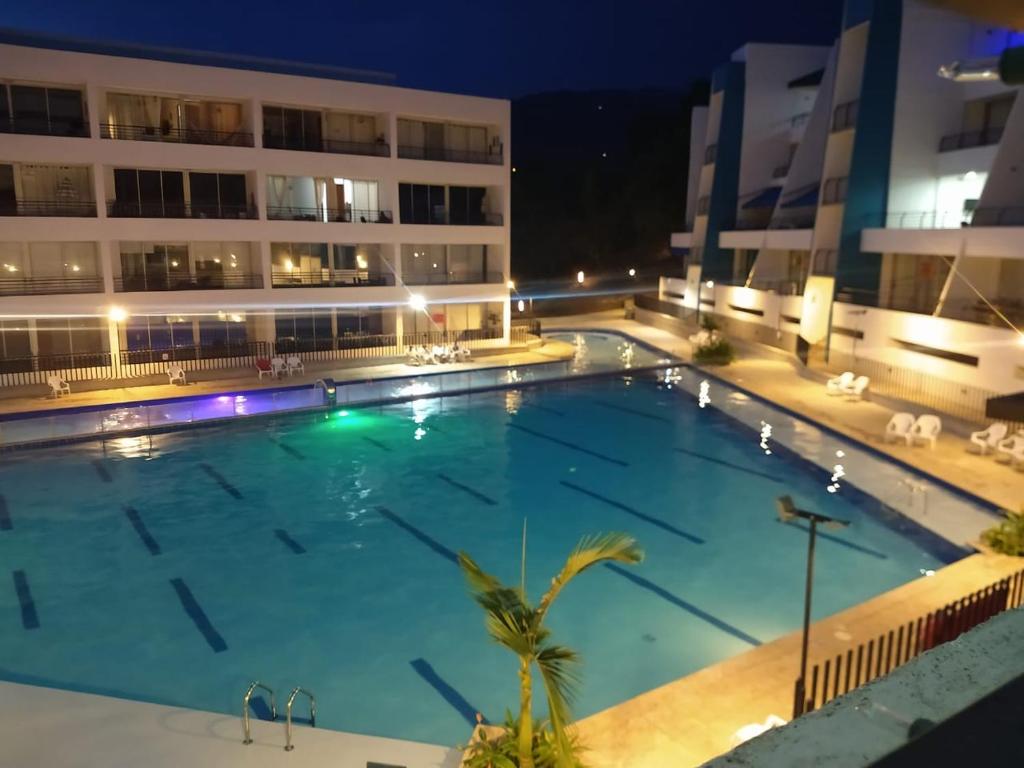 a large swimming pool in front of a building at night at Apartasol San Jerónimo in San Jerónimo