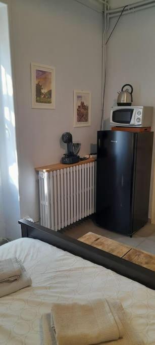 a room with a bed and a microwave on a wall at Chambre d&#39;Hotes Lamanon, avec ou sans petit déjeuner - Domaine Les Peupliers - in Lagnes