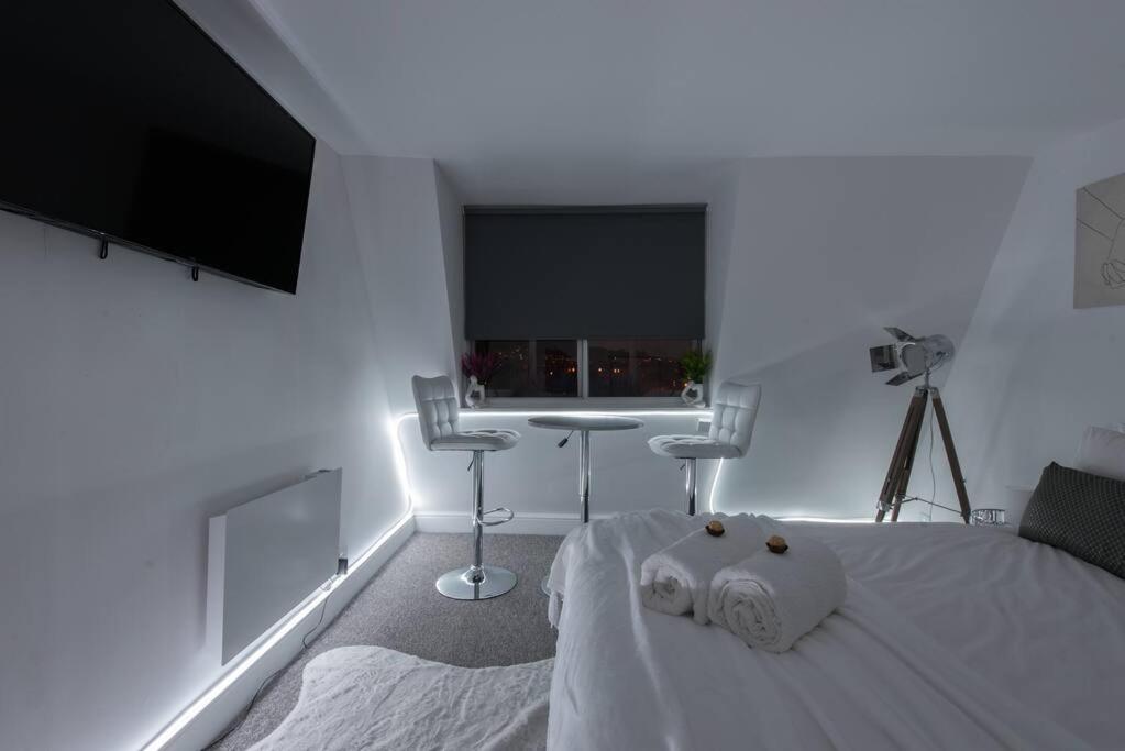 a bedroom with a bed and a table and a window at Parade Paradise- Secret Views, LEDs, 4K TVs, 5G WIFI and more! in Bath