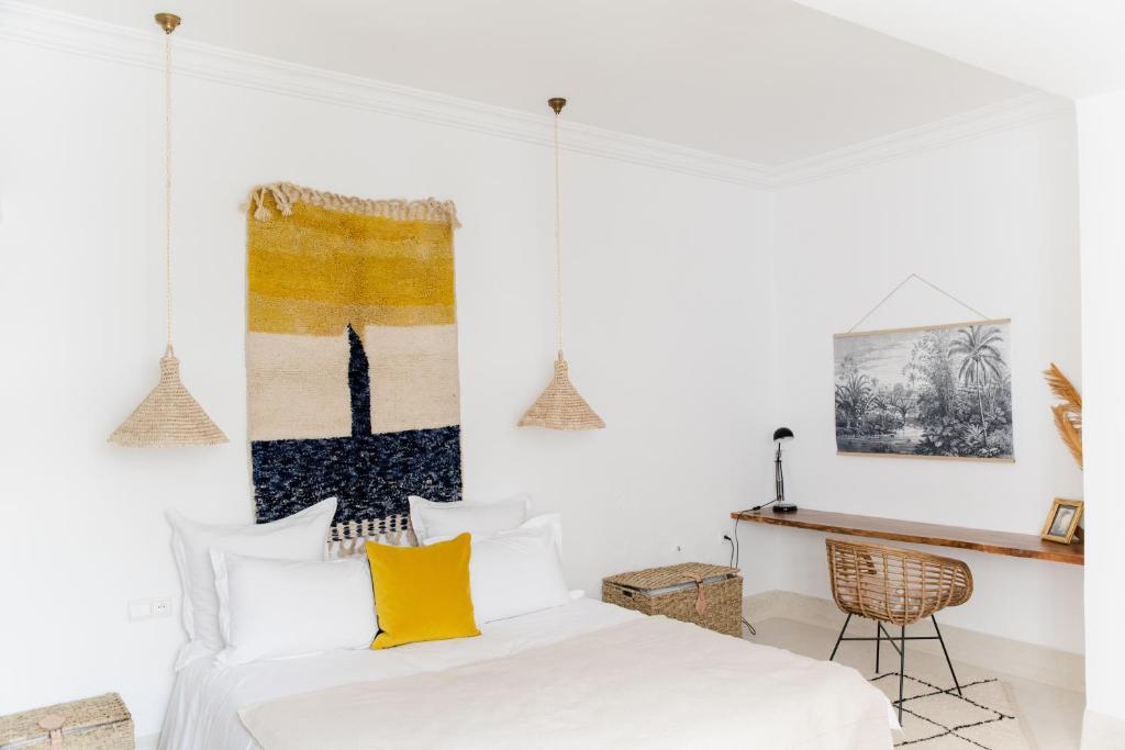 a bedroom with a white bed with yellow pillows at Riad 27 in Marrakesh