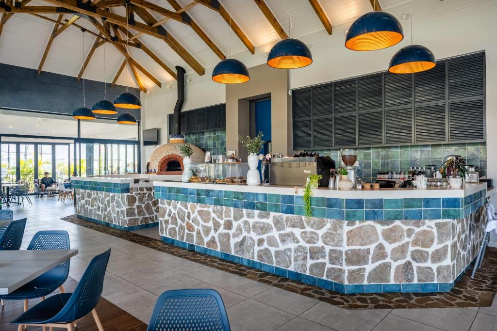 a restaurant with a stone counter and blue chairs at Ballito Hills 169 in Ballito