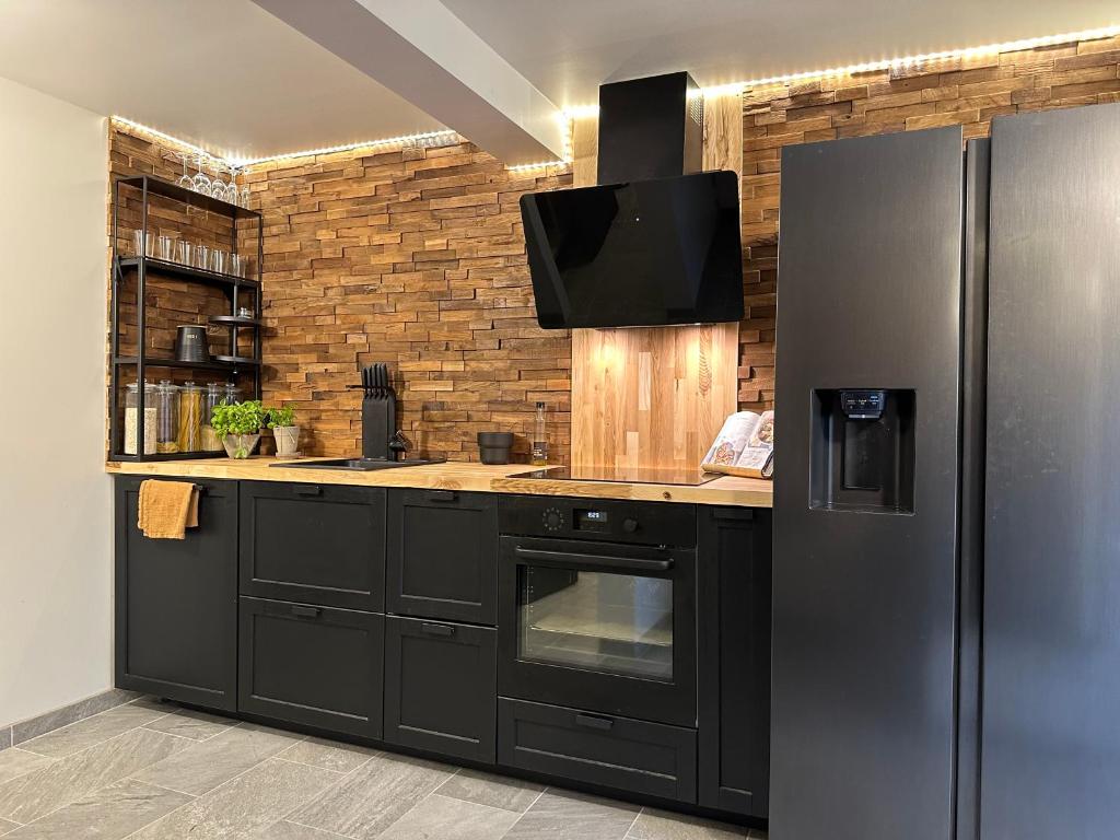 a kitchen with a black refrigerator and a tv at A Place To Stay Stavanger, apartment 1 in Stavanger