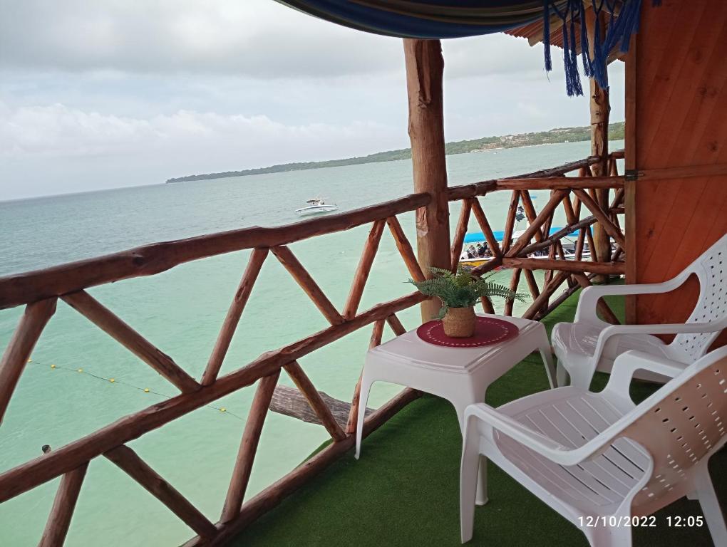 een veranda met stoelen en een tafel en de oceaan bij Posada chikiluky beach in Playa Blanca