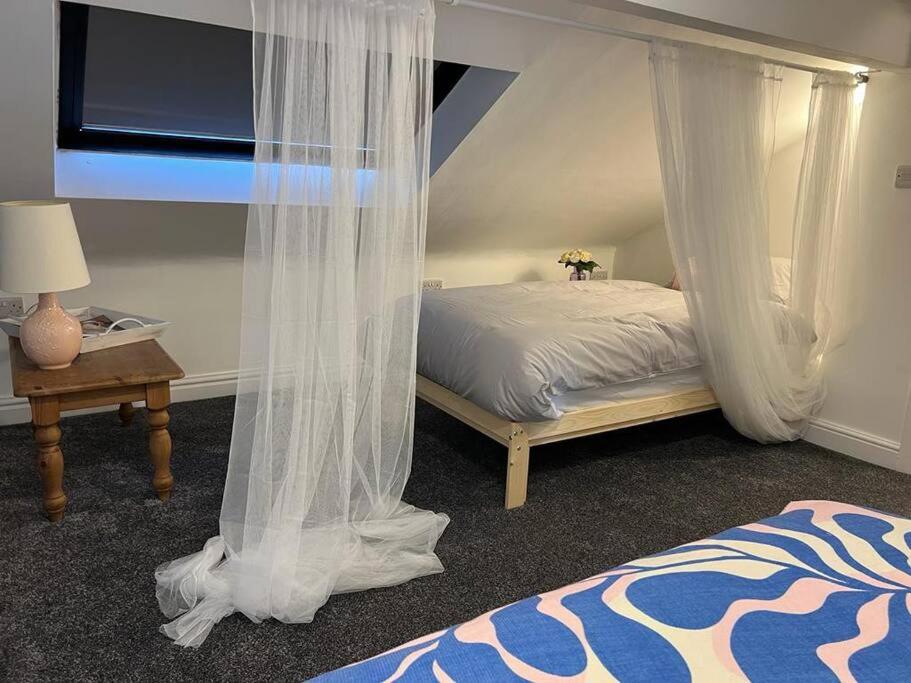 a bedroom with a bed with mosquito netting at Santiago Suite 4 - A Beautiful Duplex Flat in Southport