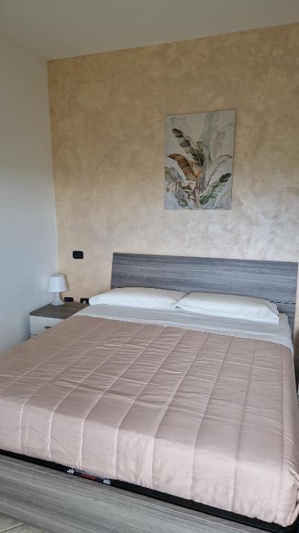 a bedroom with a large bed with a tan comforter at Flowers Apartment in Villa Caldari