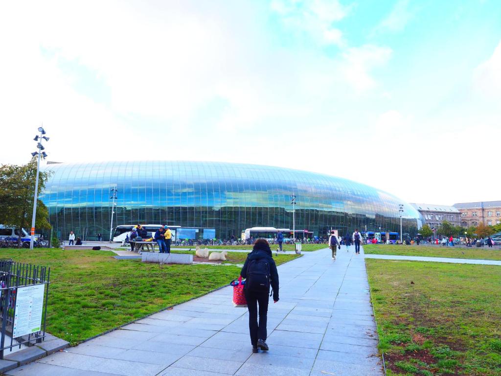 une femme marchant sur un trottoir devant un stade dans l'établissement STB2, à Strasbourg