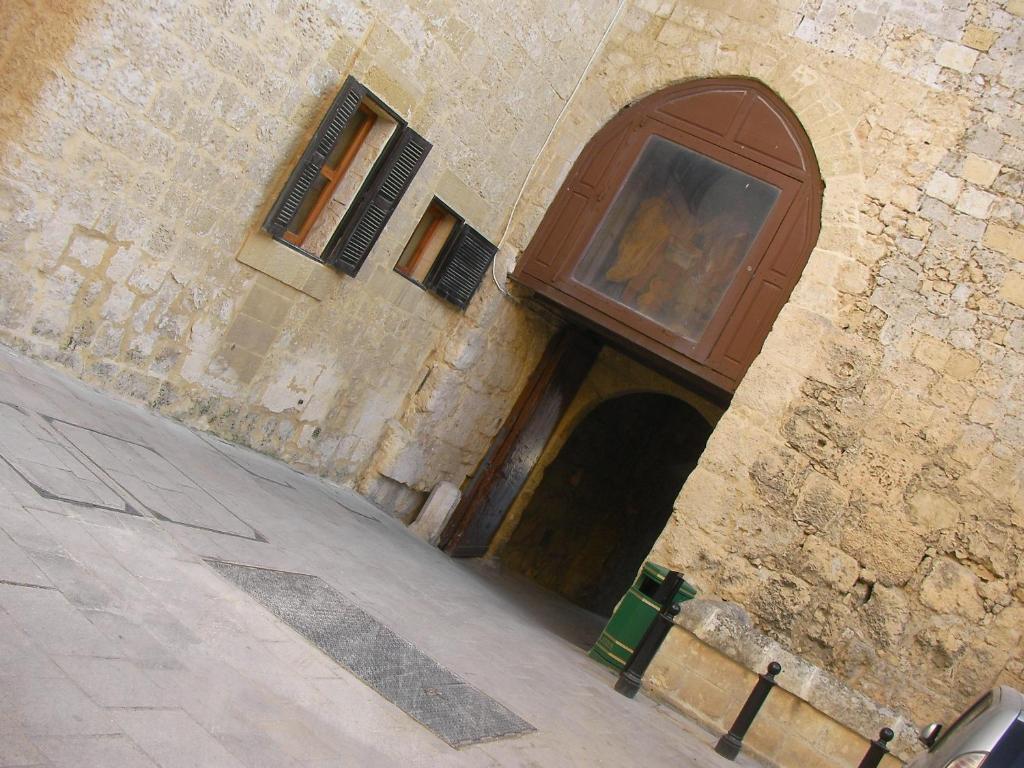 un edificio de piedra con una gran puerta de madera. en Guard Tower, en Mdina