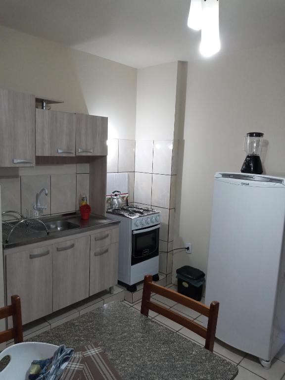 a small kitchen with a stove and a refrigerator at Apartamento 1 in Florianópolis