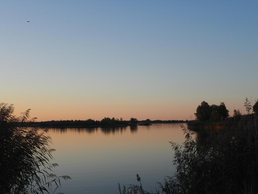 - une vue sur une étendue d'eau au coucher du soleil dans l'établissement Jarmen Ferienwohnung, à Jarmen
