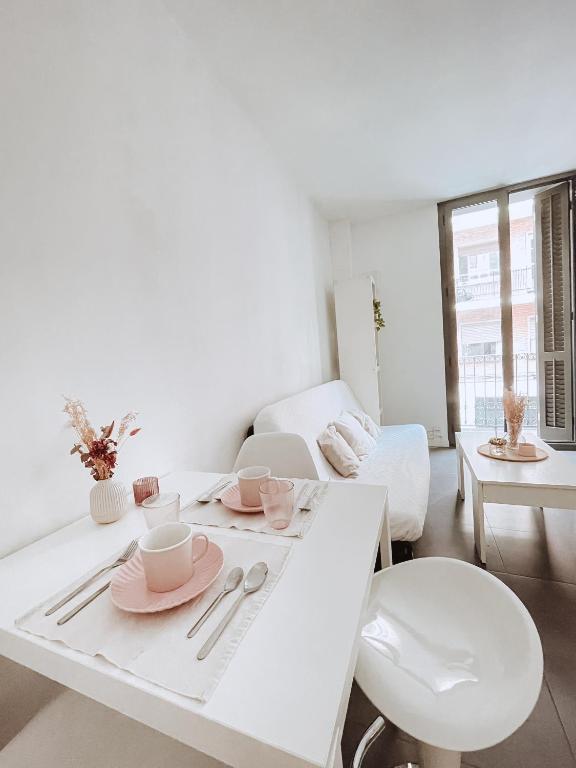 a white living room with a table and chairs at Alojamiento Vilardell in Barcelona