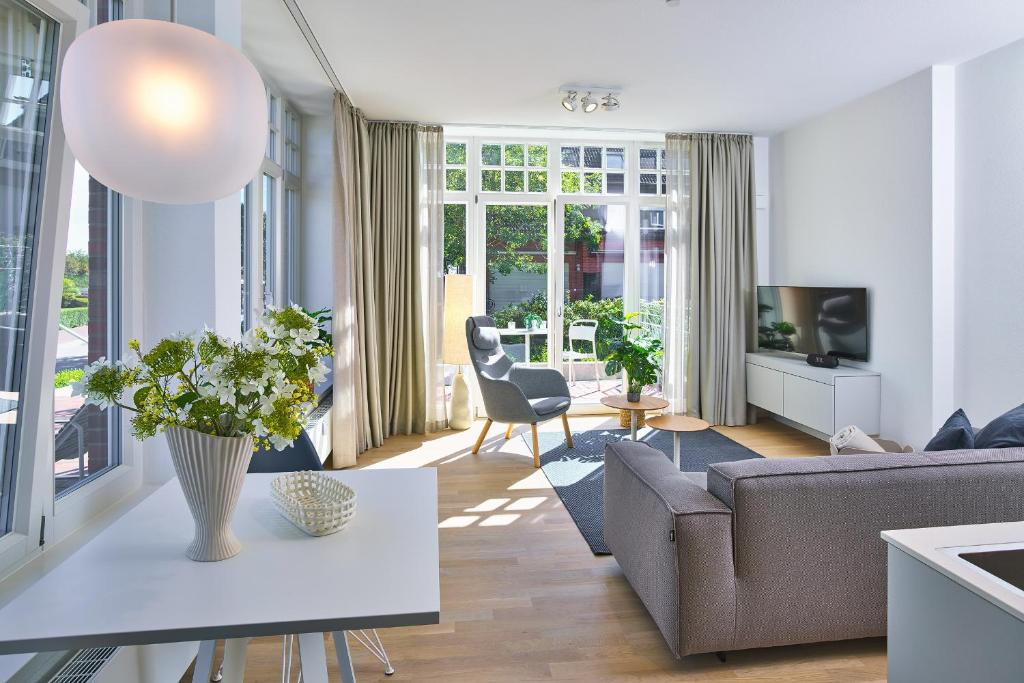 una sala de estar con un sofá y una mesa en Lüttjeod Apartmentvilla 01, en Langeoog