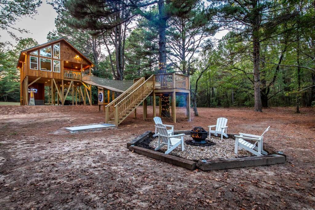 een blokhut met 2 stoelen en een speeltuin bij Romantic getaway in the treetops in Cabot