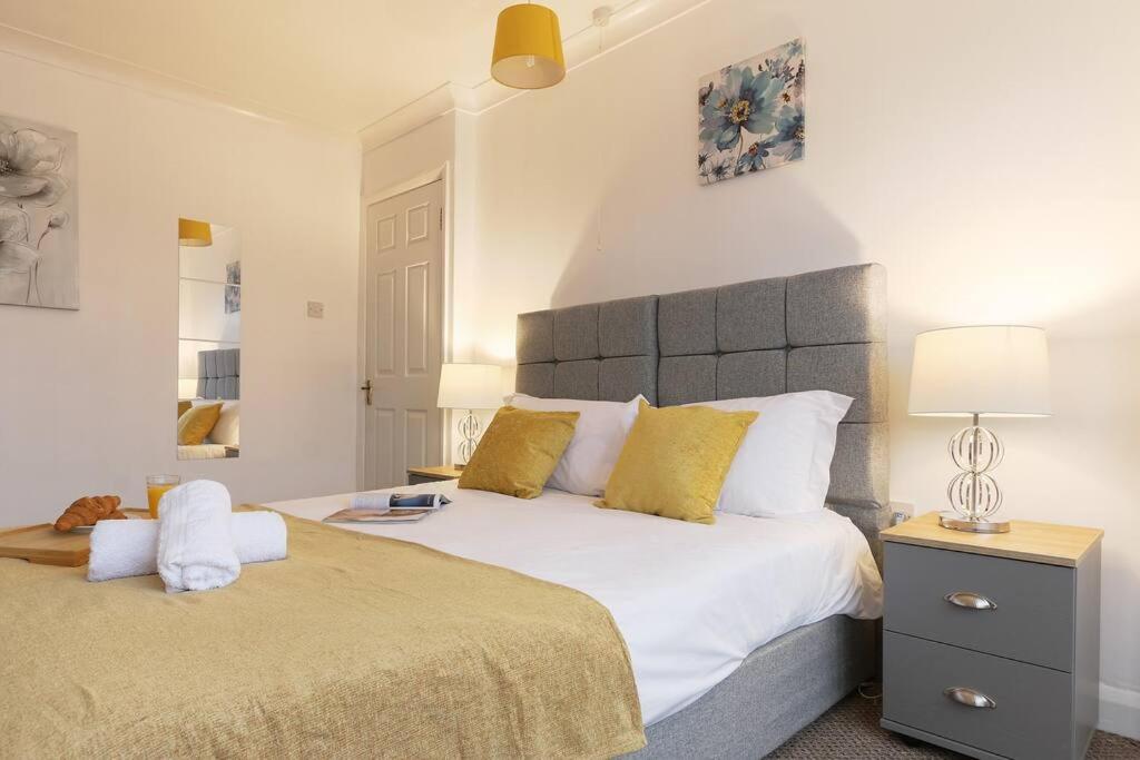 1 dormitorio con 1 cama blanca grande con almohadas amarillas en Large 4 bed Coventry house Contractors Professionals Private parking Close to NEC, en Parkside