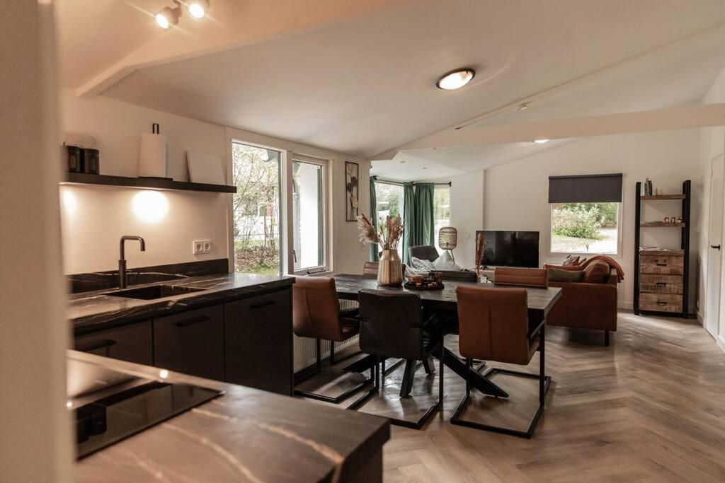 eine Küche und ein Wohnzimmer mit einem Tisch und Stühlen in der Unterkunft Fenna's Holiday Home in Exloo